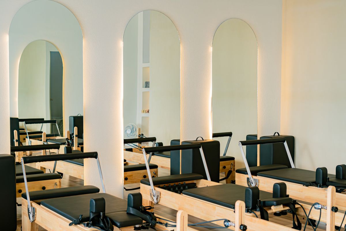 Estúdio de pilates iluminado com aparelhos reformer